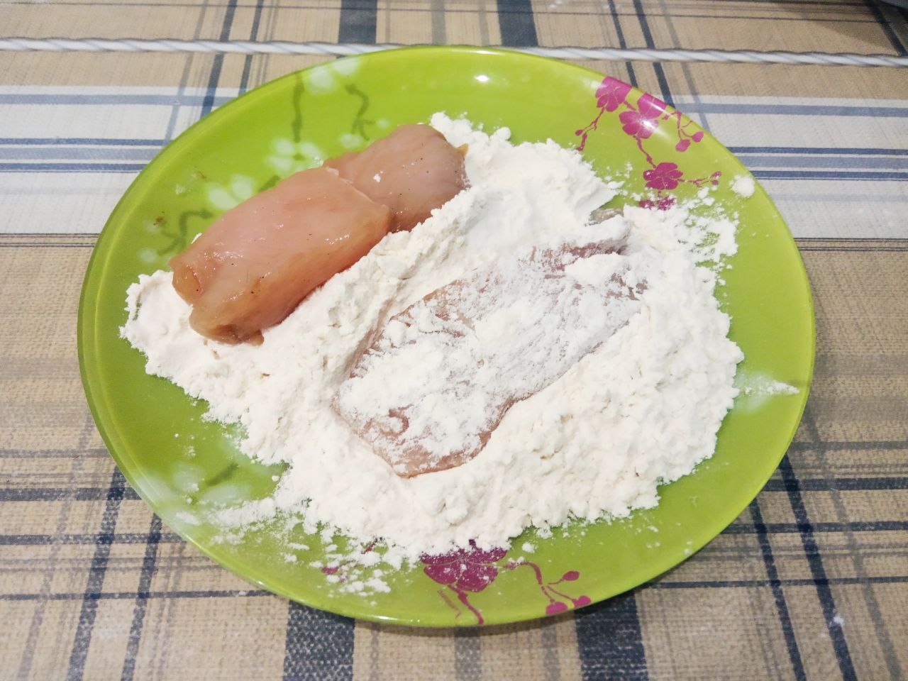 Запеченные куриные полоски в кляре и чипсах, нежные и сочные: В тарелку насыпаем муку и обваливаем полоски со всех сторон.