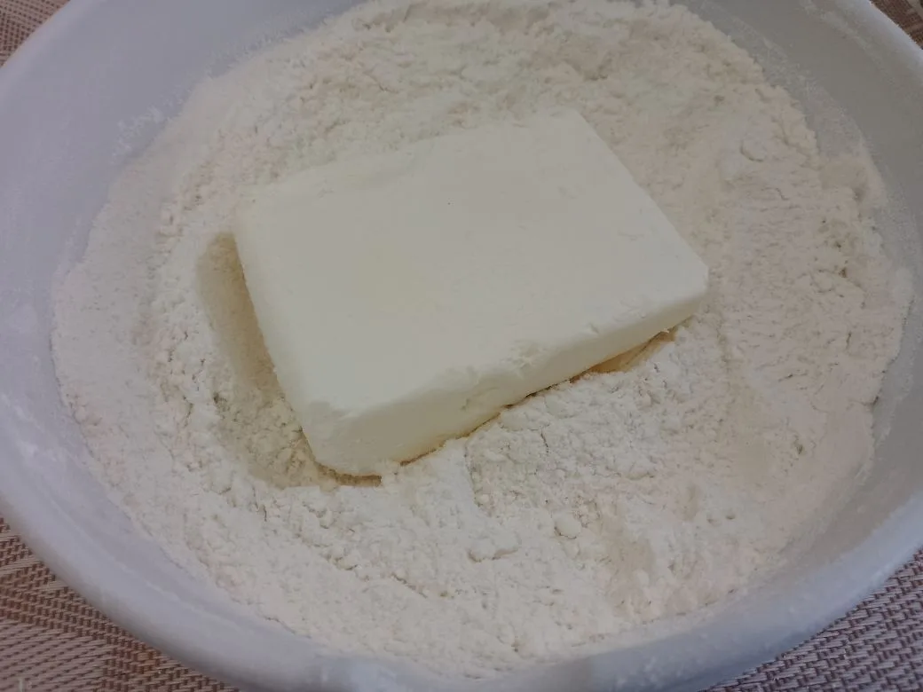 Простой рецепт печенья с кокосовой стружкой, без яиц: Кладем сливочное масло или маргарин и растираем в мелкую крошку.