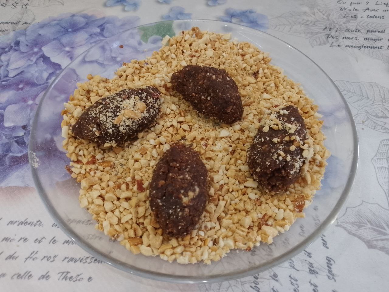Домашние пирожные «Картошка», вкусно и просто: Пирожные обваливаем в орехах и складываем на блюдо.