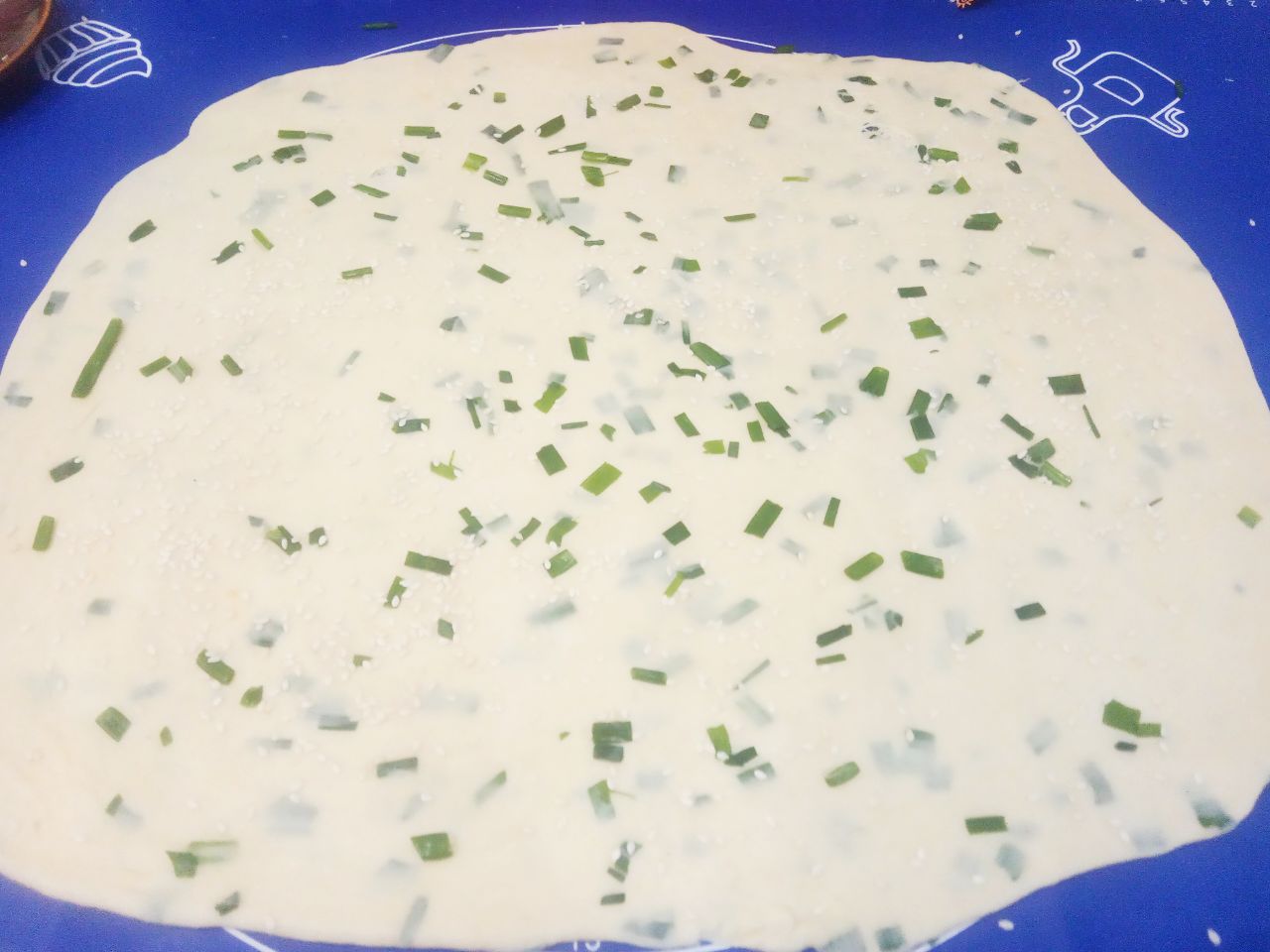 Солёное печенье с кунжутом и зеленым луком: Выкладываем тесто на рабочую поверхность, накрываем пергаментом и раскатываем толщиной, чем тоньше тесто тем