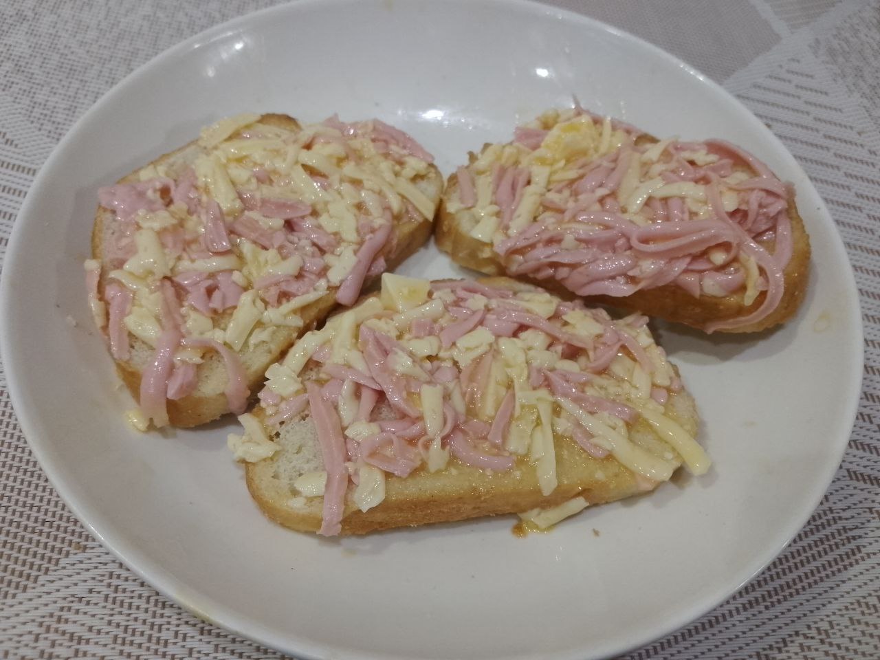Бутерброды с яйцами и сыром, жареные на сковороде: Равномерно распределяем смесь по ломтикам батона.
