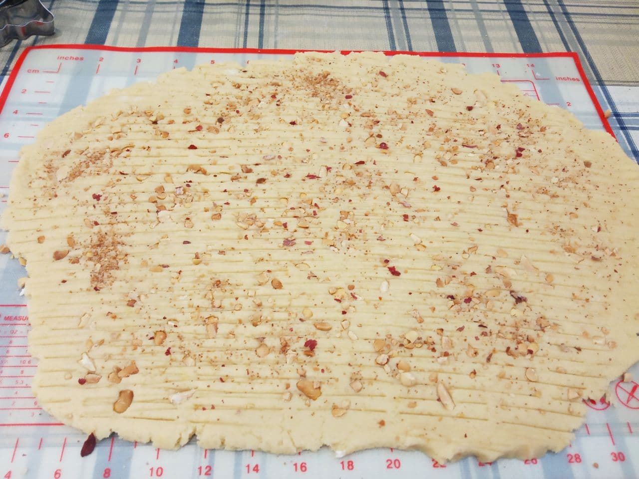 Рассыпчатое песочное домашнее печенье с крахмалом, вкусно и просто: Лист теста посыпаем измельченными орехами и по желанию валиком продавливаем узоры.