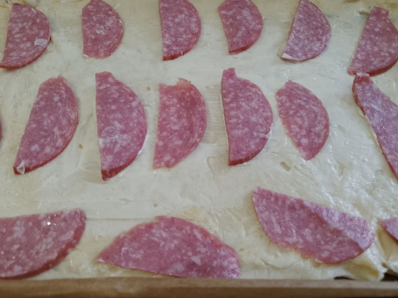 Домашняя пицца с шампиньонами, колбасой, помидорами и сыром: Равномерно распределяем колбасу по своему вкусу.