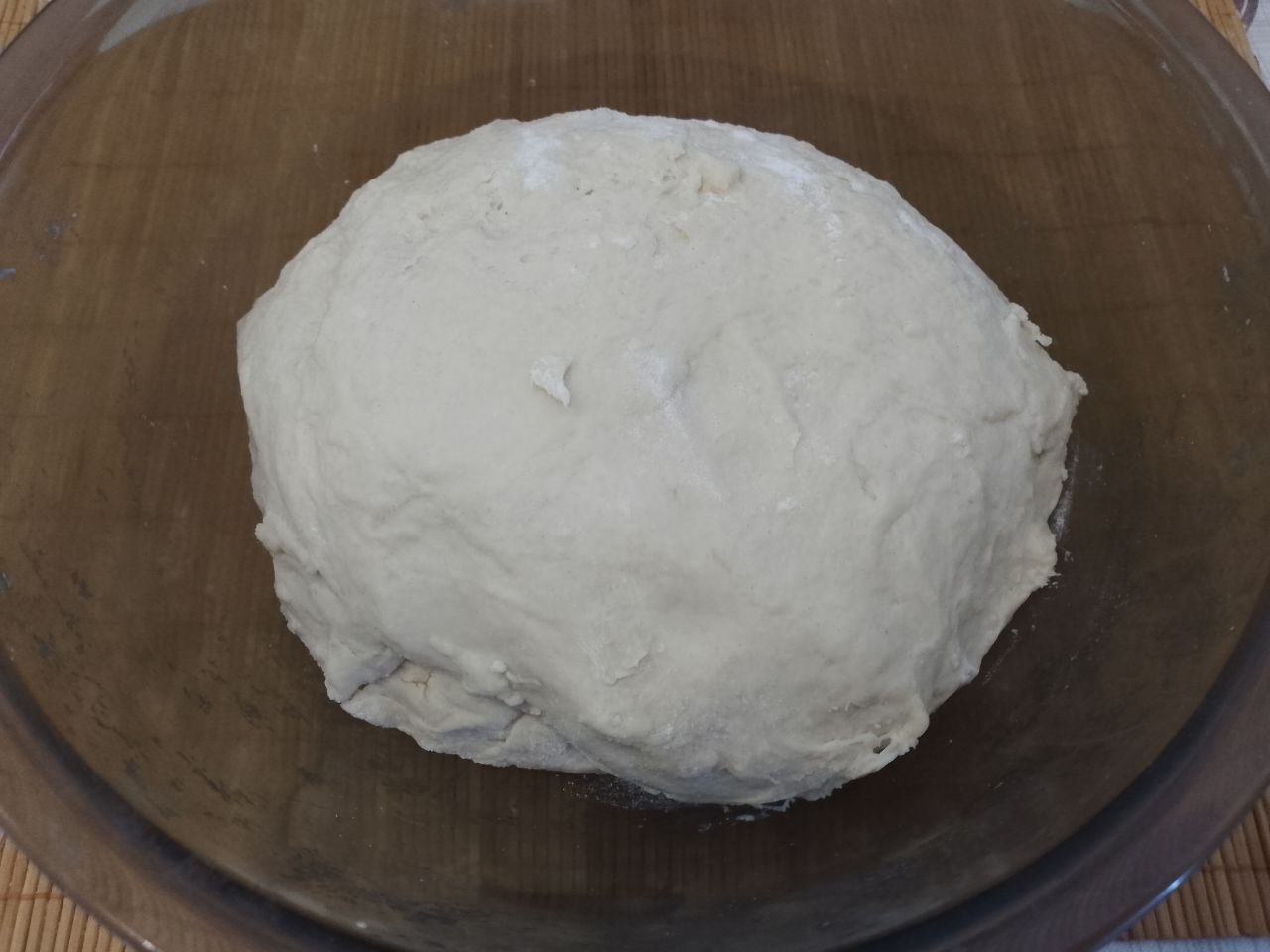 Пирожки из дрожжевого теста на сметане, с мясной начинкой, жареные на сковороде: Добавляем муку частями в тесто, замешиваем нежное и эластичное тесто.