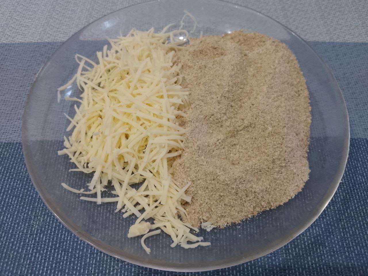Курица пармиджано с протертыми помидорами и сыром: Насыпаем в тарелку панировочные сухари, добавляем сыр, перемешиваем.