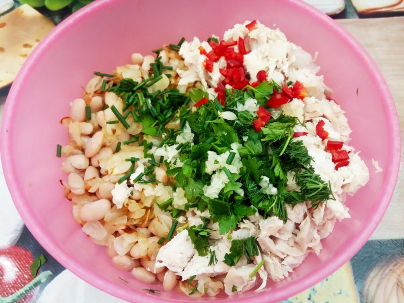Салат из фасоли, куриного филе и жаренного лука: В чашу выкладываем фасоль, куриное мясо, жареный лук, чеснок и мелко нарезанный горький перец, перемешиваем.