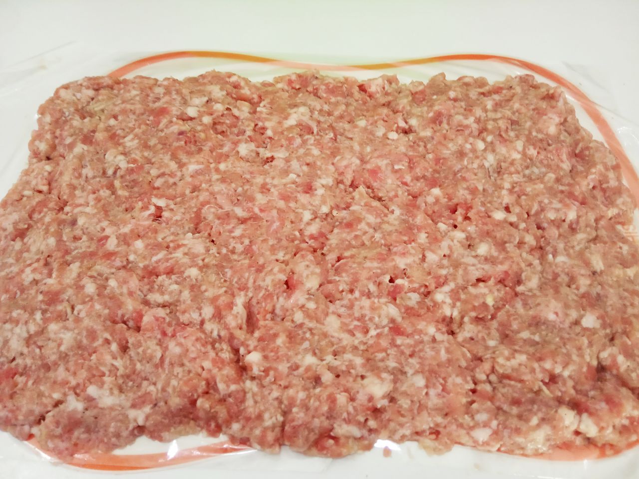 Мясной рулет с сыром в кляре, жареный на сковороде: Затем застилаем пищевую пленку разравниваем котлетную массу равномерно прямоугольником.