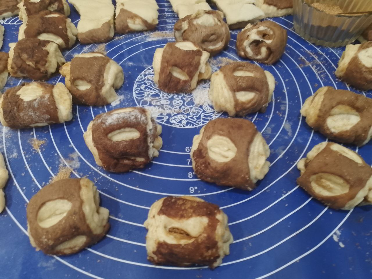 Булочки из слоеного теста с корицей и изюмом: Переворачиваем прямоугольники светлой стороной, посыпаем корицей с сахаром половину прямоугольников,
