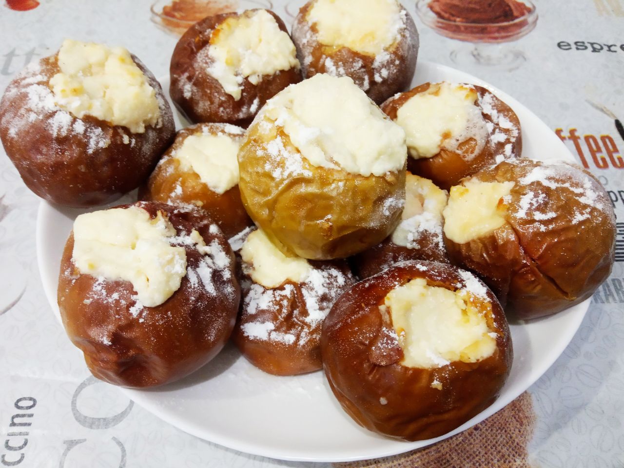 Вкусный десерт, запеченные яблоки с творогом и сливочным маслом: Испеченные яблоки достаем из духовки и посыпаем сахарной пудрой. Выкладываем яблоки на блюдо и подаем к столу.