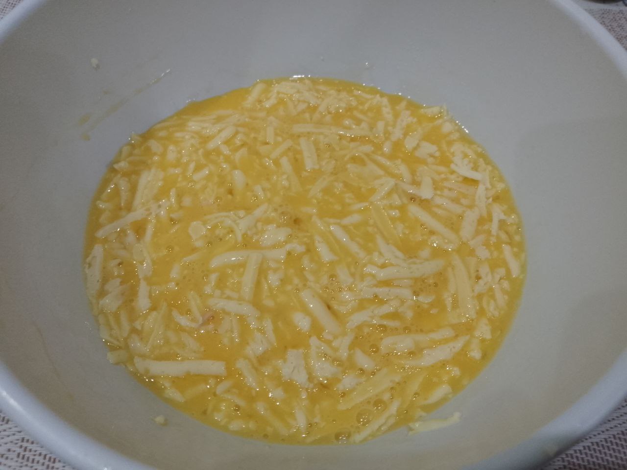 Бутерброды с яйцами и сыром, жареные на сковороде: Смешиваем яйца с сыром.