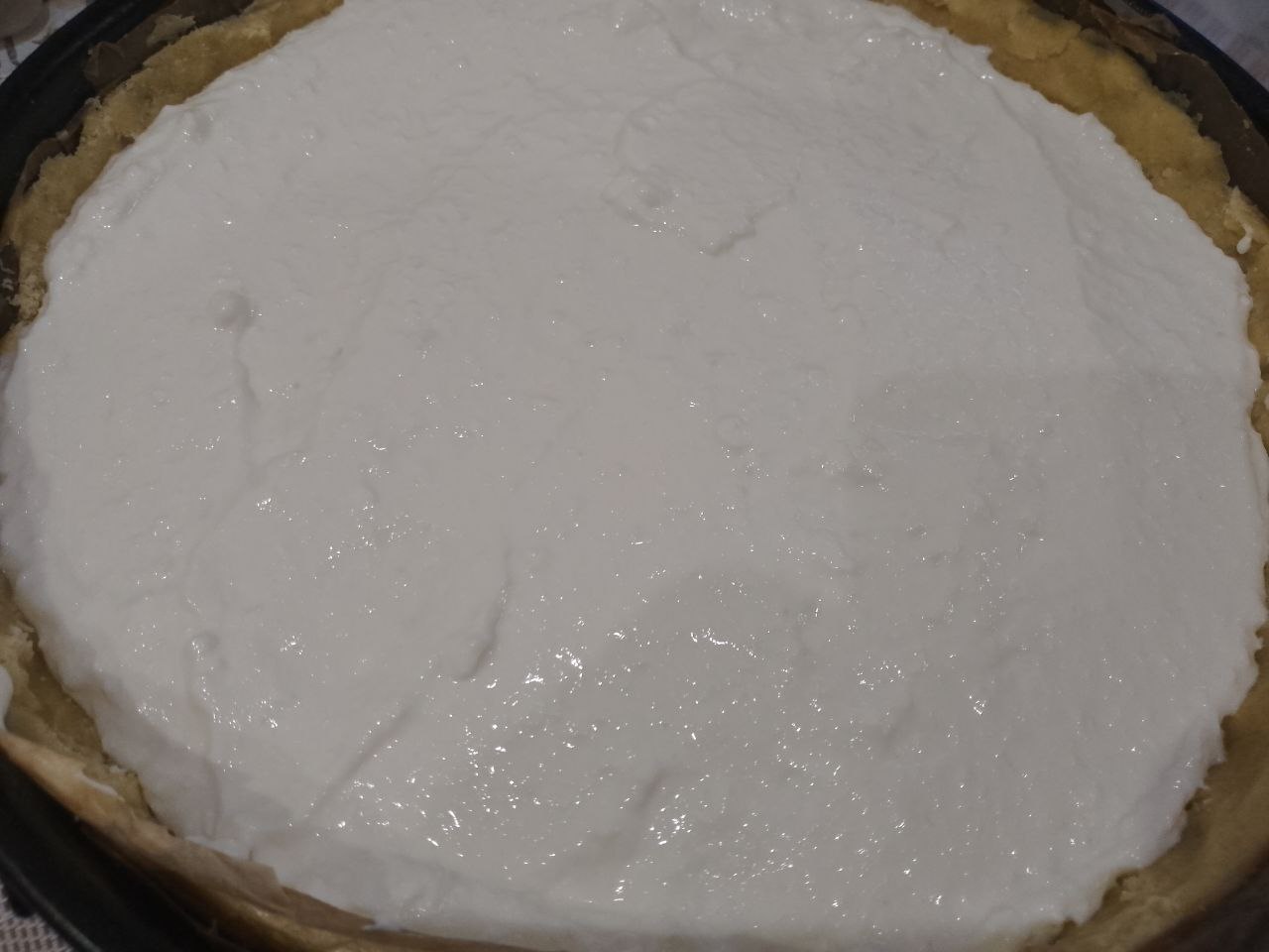 Пирог из песочной крошки, с творожной начинкой и замороженными ягодами: Достаем форму с тестом с холодильника и выкладываем начинку, разравниваем.