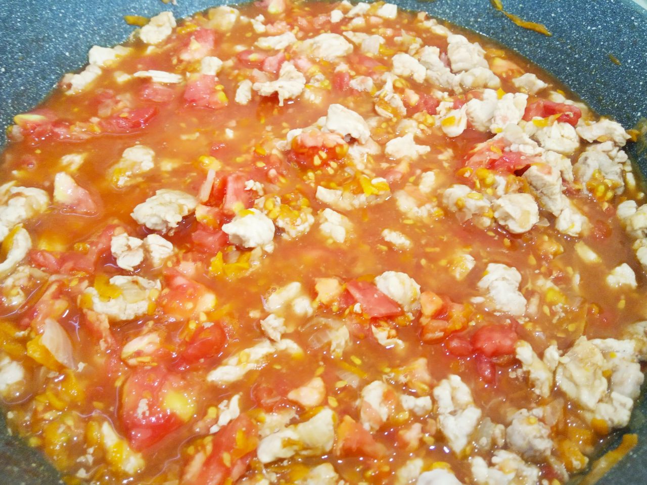 Запеченные помидоры с мясной начинкой и сыром: Выкладываем измельченные помидоры и обжариваем до испарения жидкости.
