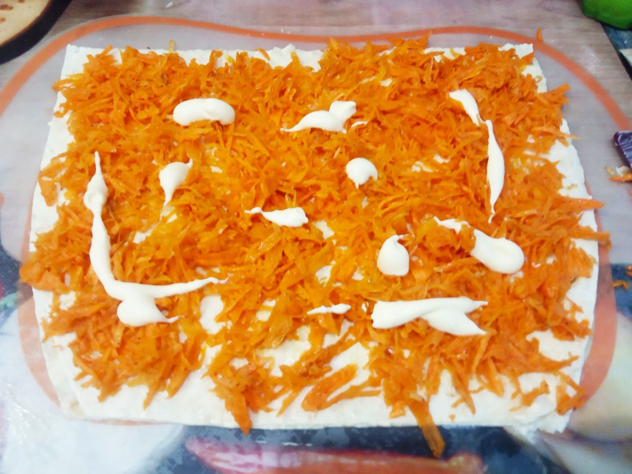 Лаваш с начинкой из сыра, овощей и мяса, просто и вкусно: Сверху на майонез выкладываем слой корейской моркови не до самого края лаваша и также смазываем майонезом.