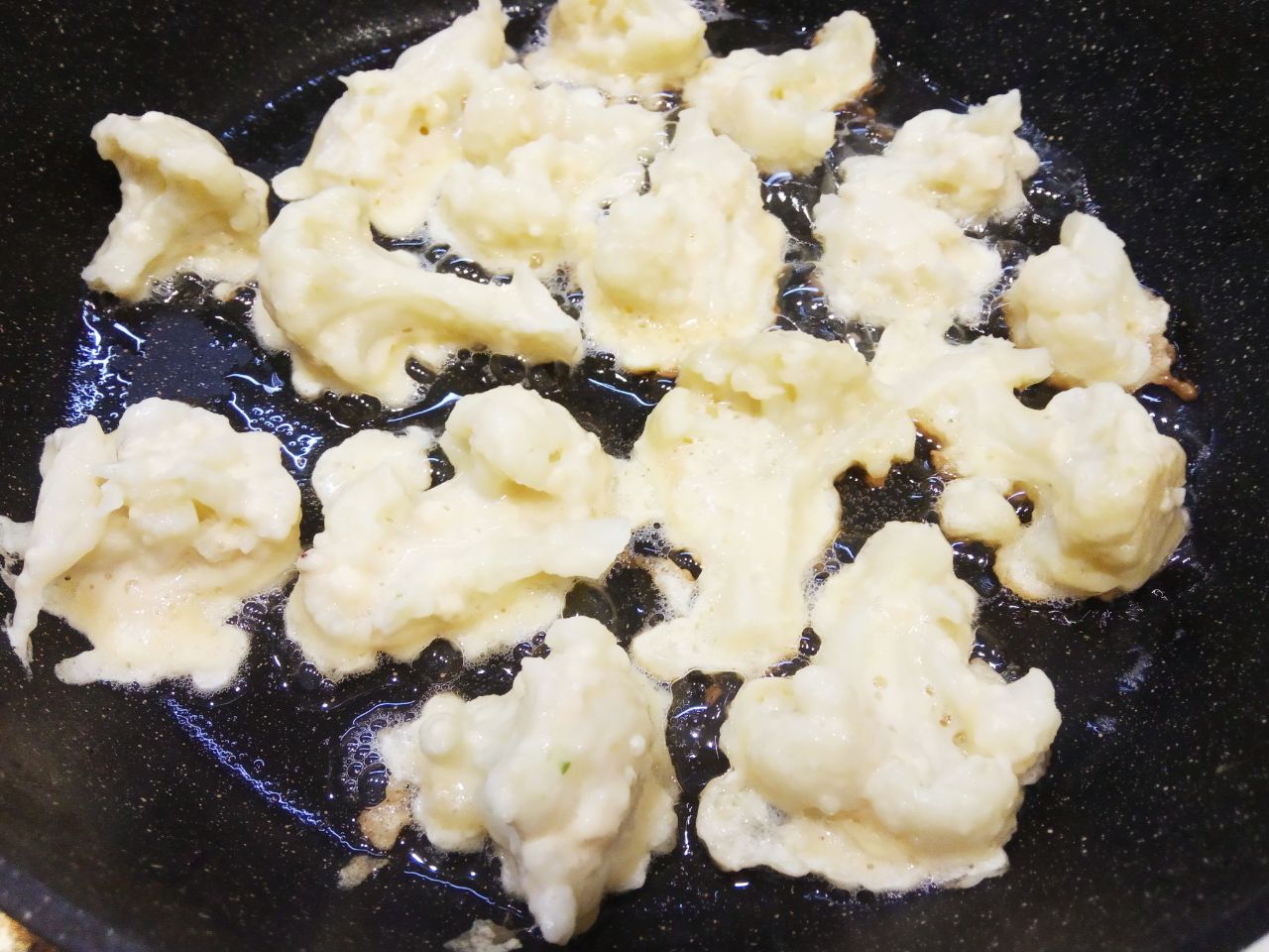 Цветная капуста в кляре, просто и вкусно: Разогреваем сковороду с растительным маслом и вилкой окунаем кусочки в кляр.