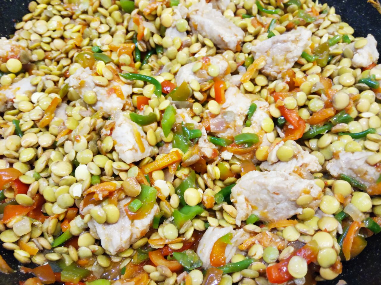 Тушеная чечевица со свининой и овощами, сытно и вкусно: Из чечевицы сливаем воду, промываем и добавляем в сковороду, перемешиваем.