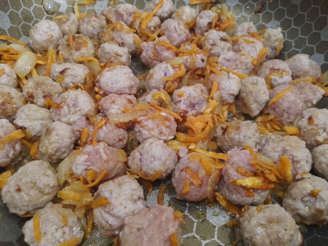 Капуста тушеная в сметане с мясными шариками, просто и вкусно: Кладем мясные шарики к обжаренным овощам и обжариваем несколько минут.