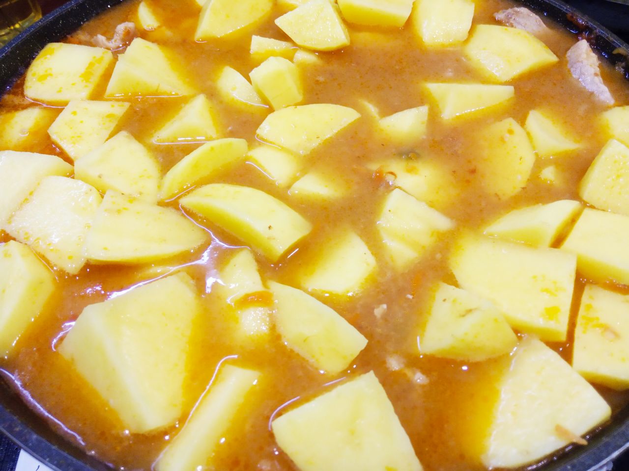 Картофель тушеный со свининой и овощами, сытный и аппетитный: Сливаем воду с картофеля и картофель кладем в кипящее тушеное мясо в соусе. Картофель должен быть покрытый