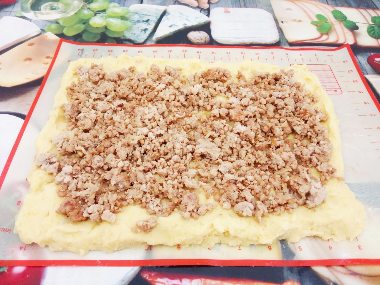 Картофельный рулет с мясной начинкой, запеченный в духовке: На картофельное тесто выкладываем обжаренный фарш, равномерно разравниваем.