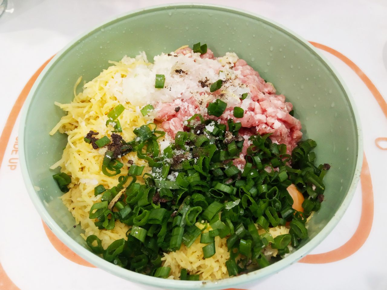 Котлеты из тертого картофеля, фарша и зеленого лука, вкусно и сытно: В посуде или миске соединяем отжатый тертый картофель, фарш, измельченные чеснок и зелёный лук, яйцо или
