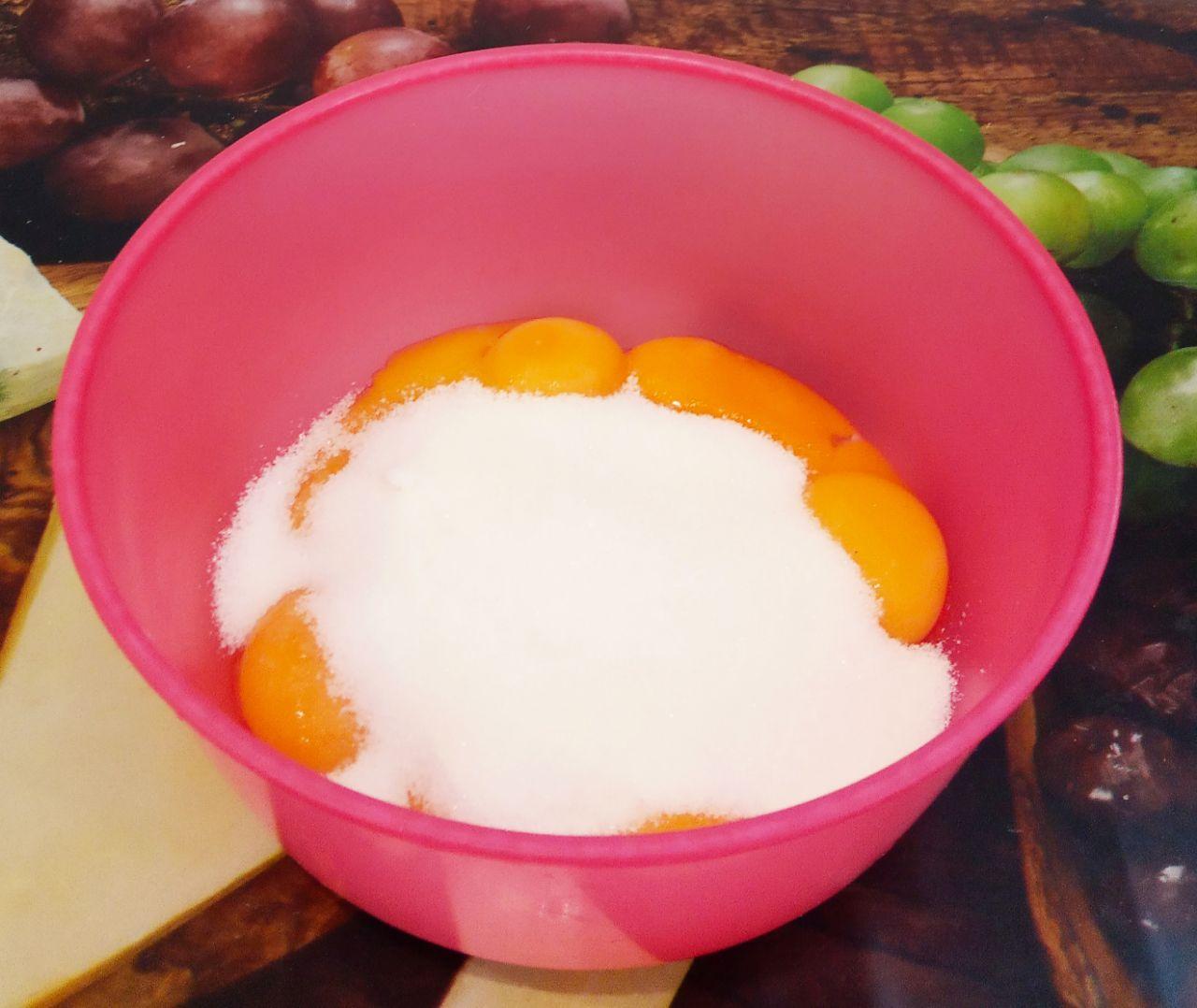 Торт из сухарей, с нежным заварным кремом, просто и вкусно: Берем емкость для замешивания теста, выкладываем желтки и всыпаем сахар.