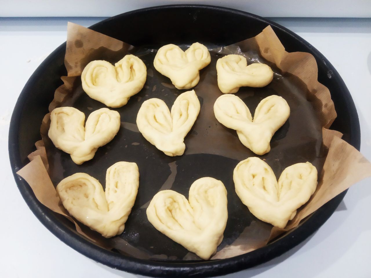 Сахарные булочки к чаю, просто и вкусно: Противень застилаем пергаментом и укладываем булочки. На половину булочек сверху выкладываем изюм. Булочки