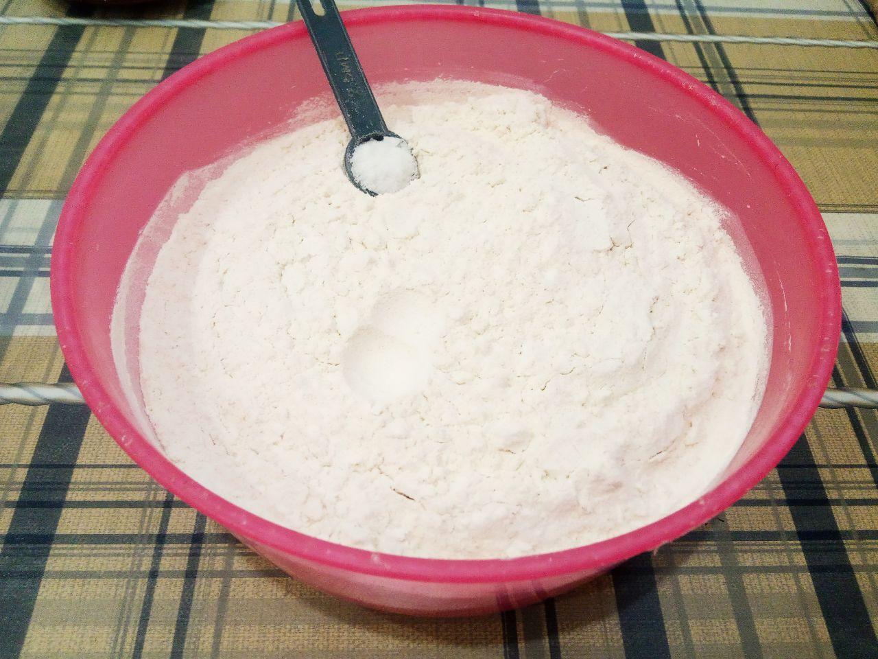 Домашние булочки с начинкой из шоколадной крошки: Муку просеиваем через мелкое сито и большую часть муки с солью добавляем в смесь.