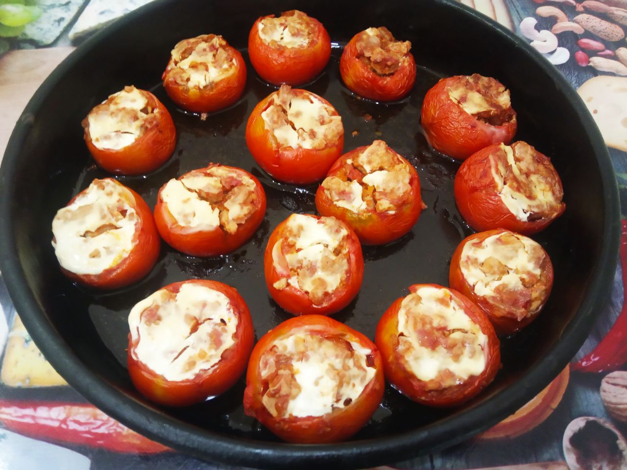 Запеченные помидоры с мясной начинкой и сыром: Достаем помидоры из духовки, посыпаем сыром и возвращаем обратно в духовку на 5 минут.