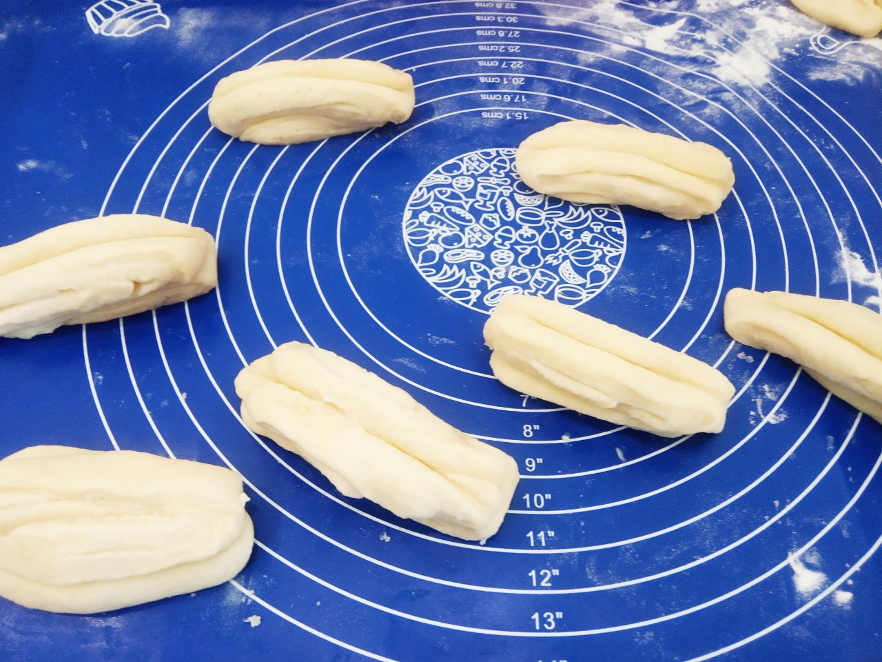 Булочки воздушные, мягкие, слоистые и вкусные: Середину полоски продавливаем шпажкой, вытягиваем, наматываем на три пальца и края соединяем.