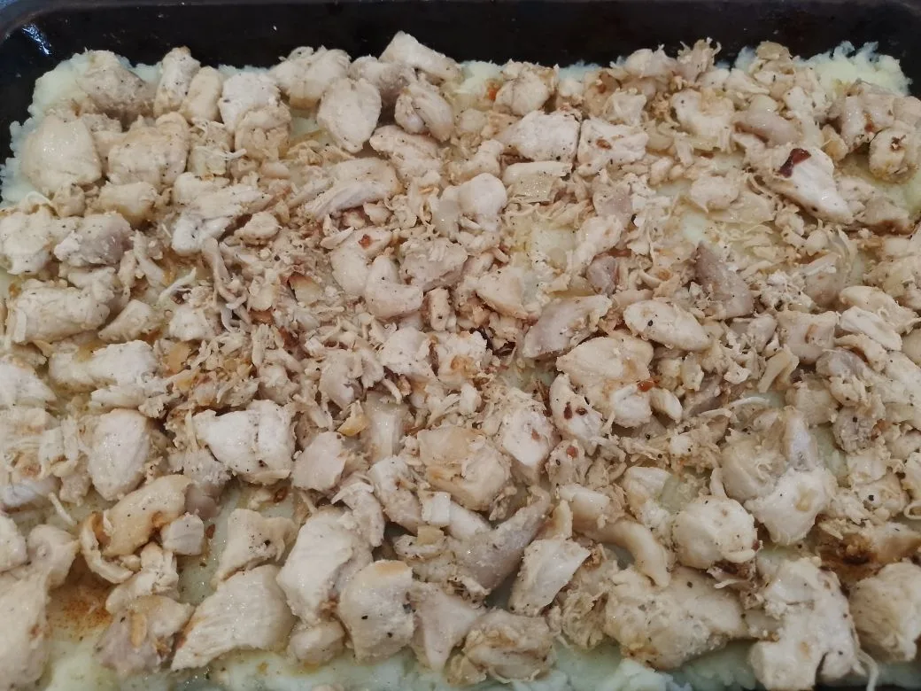 Картофельная запеканка с сыром, помидорами и куриным мясом: Выкладываем слой обжаренного мяса с луком.