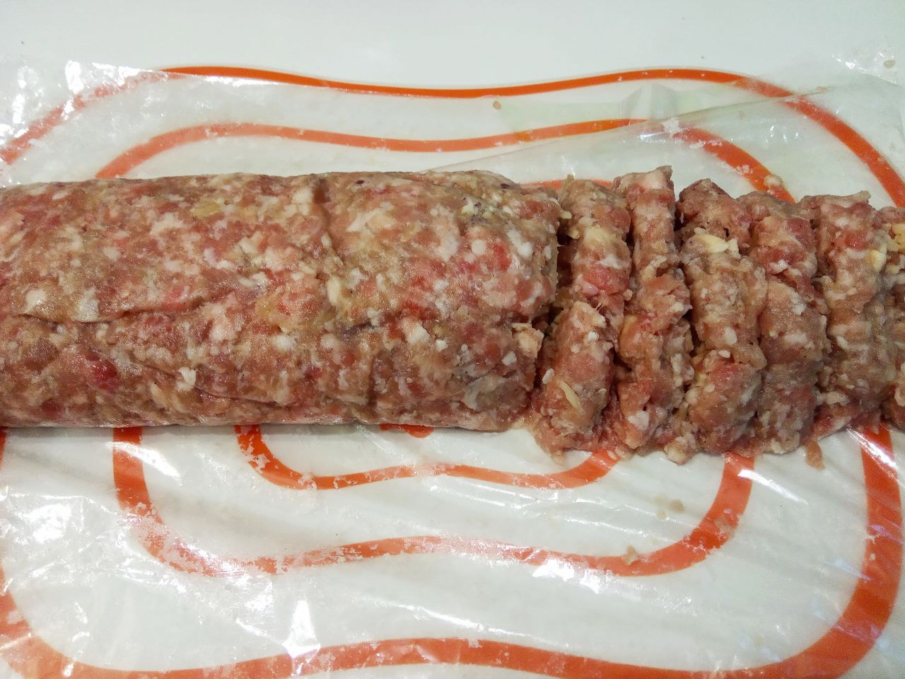 Мясной рулет с сыром в кляре, жареный на сковороде: Достаем мясной рулет с морозильной камеры и разрезаем на полоски толщиной около 1-1,5 см.