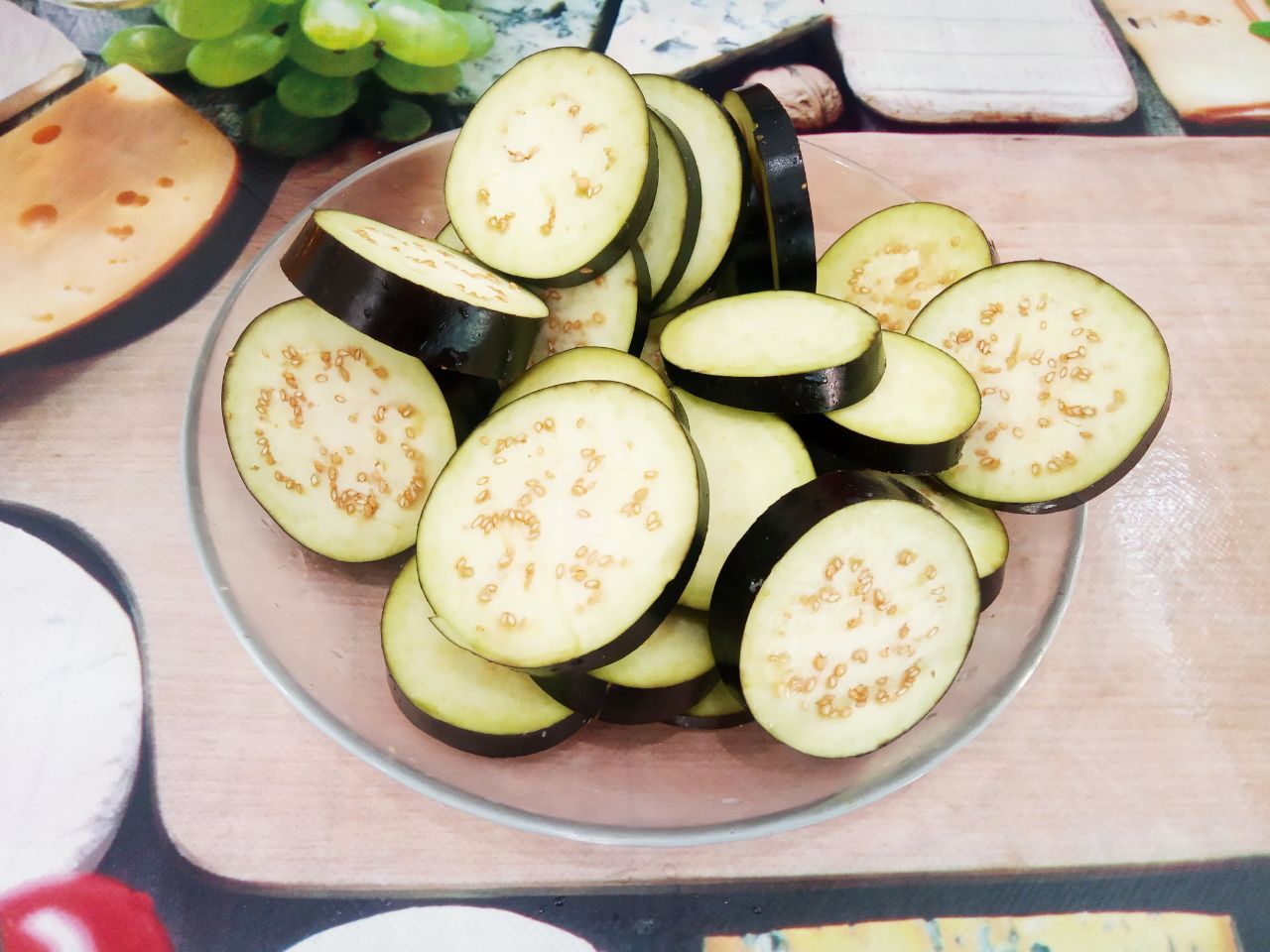 Салат из баклажанов, с помидорами и сыром: Разрезаем баклажаны на кружочки толщиной до 1 см. Замачиваем кружочки баклажанов на 20 минут в соленой воде