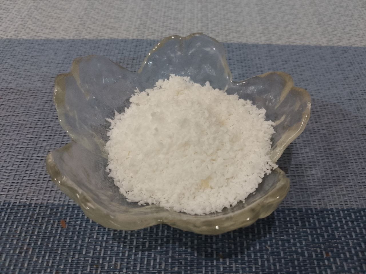 Сырники из творога, рисовой муки и кокосовой стружки: Добавляем ванильный сахар, сахар и кокосовую стружку, перемешиваем.