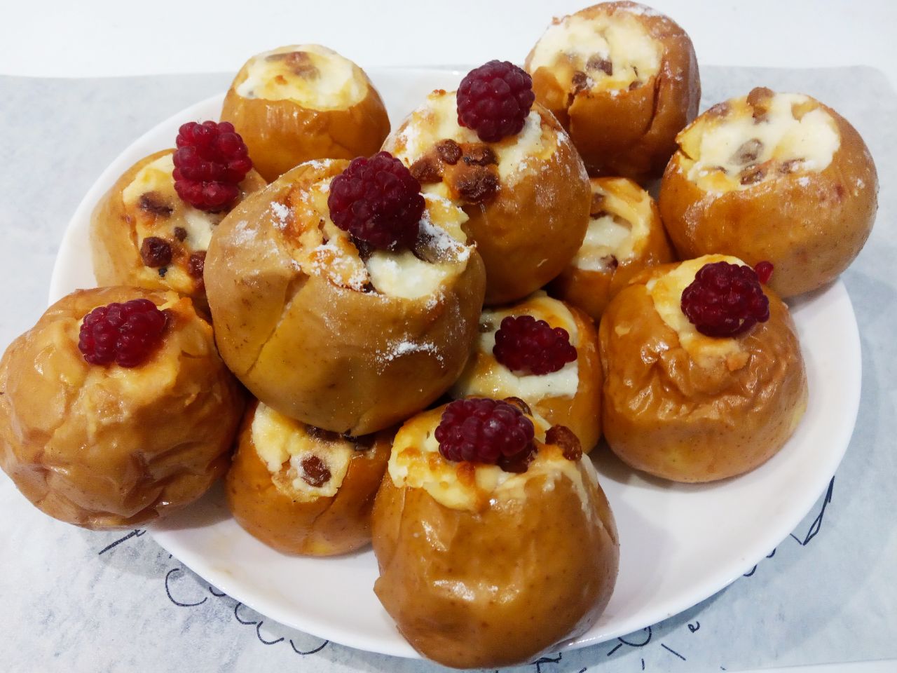 Нежные и сочные запеченные яблоки с творогом и изюмом: Достаем яблоки из духовки, посыпаем сахарной пудрой и я украсила ягодами свежей малины.