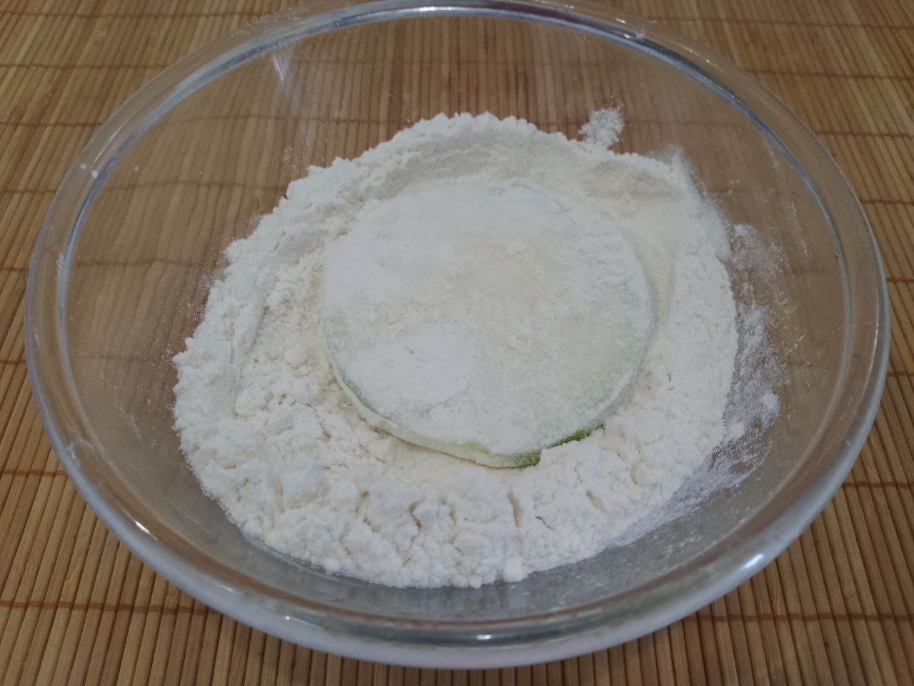 Кабачки жареные с чесноком, майонезом и укропом: В миску насыпаем муку и обваливаем кабачки.