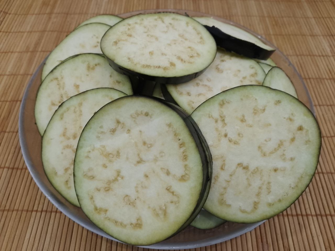 Салат из жареных баклажанов, помидоров, перца, чеснока и зелени, вкусный и аппетитный: У баклажанов отрезаем плодоножки, промываем водой и нарезаем кружочками около 1 см.Баклажаны солим и даем