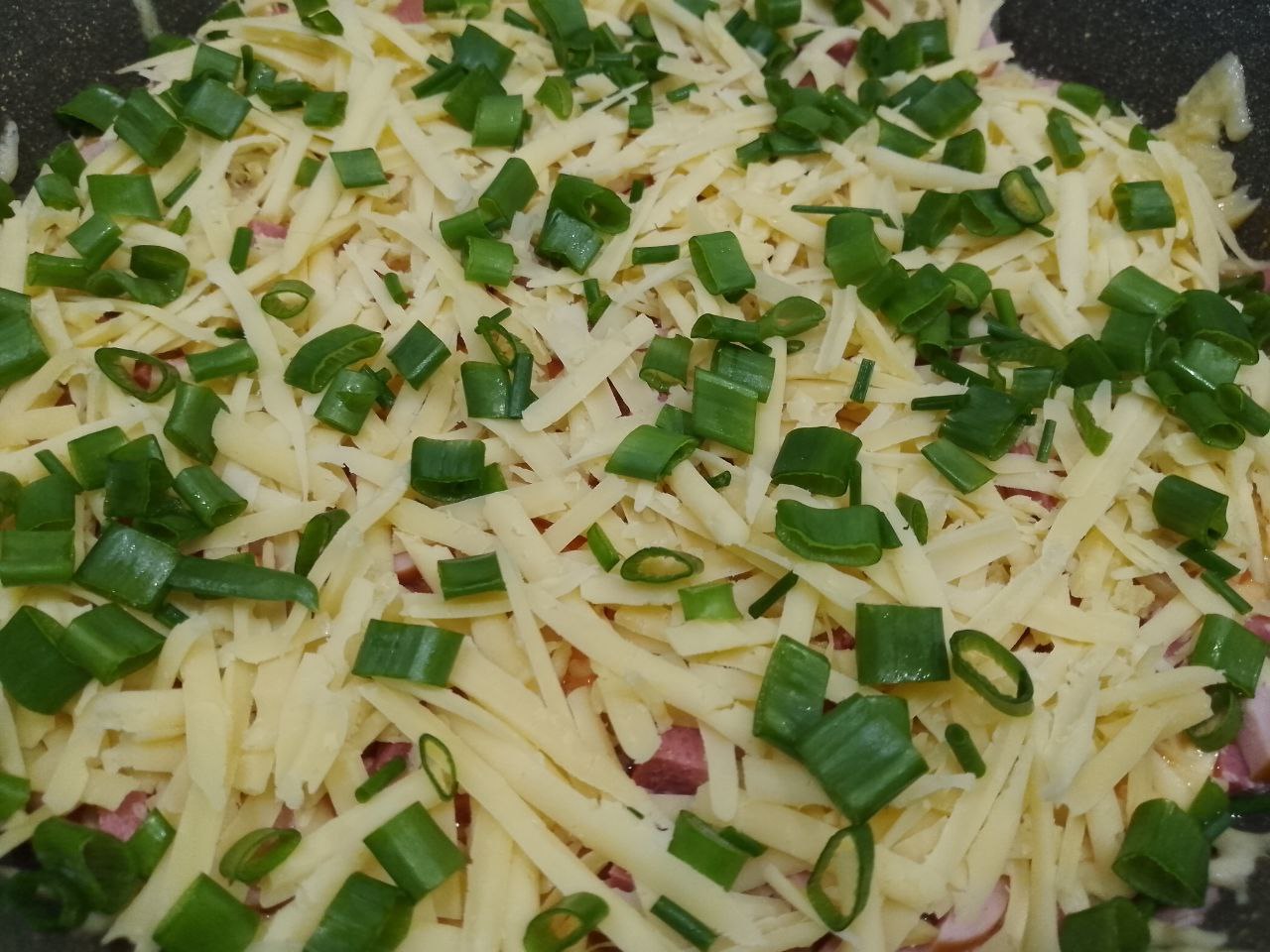Пицца на сковороде, просто, быстро и вкусно: Посыпаем тертым сыром и посыпаем зеленым луком.