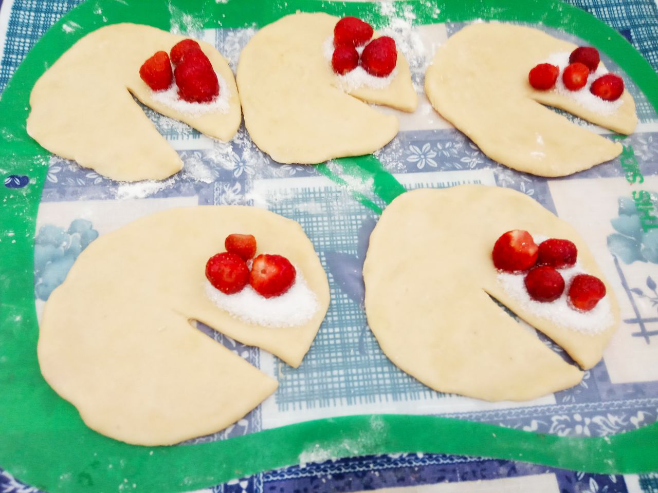 Пирожки с клубникой, из бездрожжевого теста, воздушные и рассыпчатые: На одну сторону кладем чайную ложку сахара и несколько ягод приготовленной клубники.