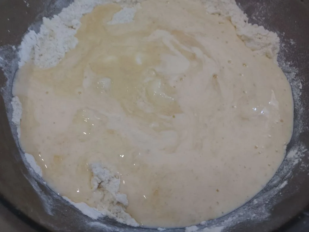 Песочное и рассыпчатое печенье, с начинкой из творога и изюма: Выливаем в мучную крошку смесь, замешиваем мягкое и нежное тесто. Тесто помещаем в холодильник на один час.