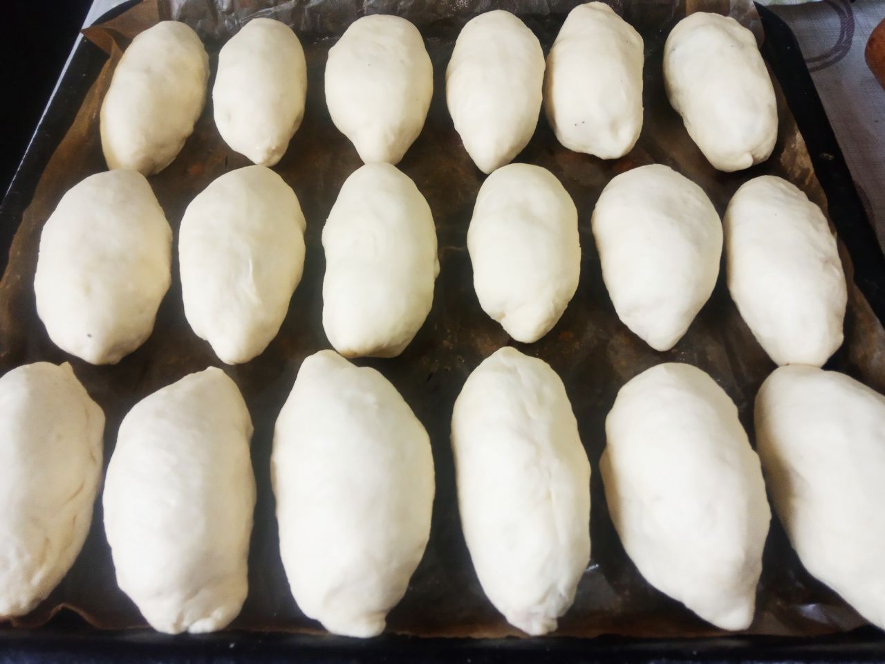 Пирожки с фасолевой начинкой в чесночной заливке, просто и вкусно: Противень застилаем пергаментом и укладываем пирожки.