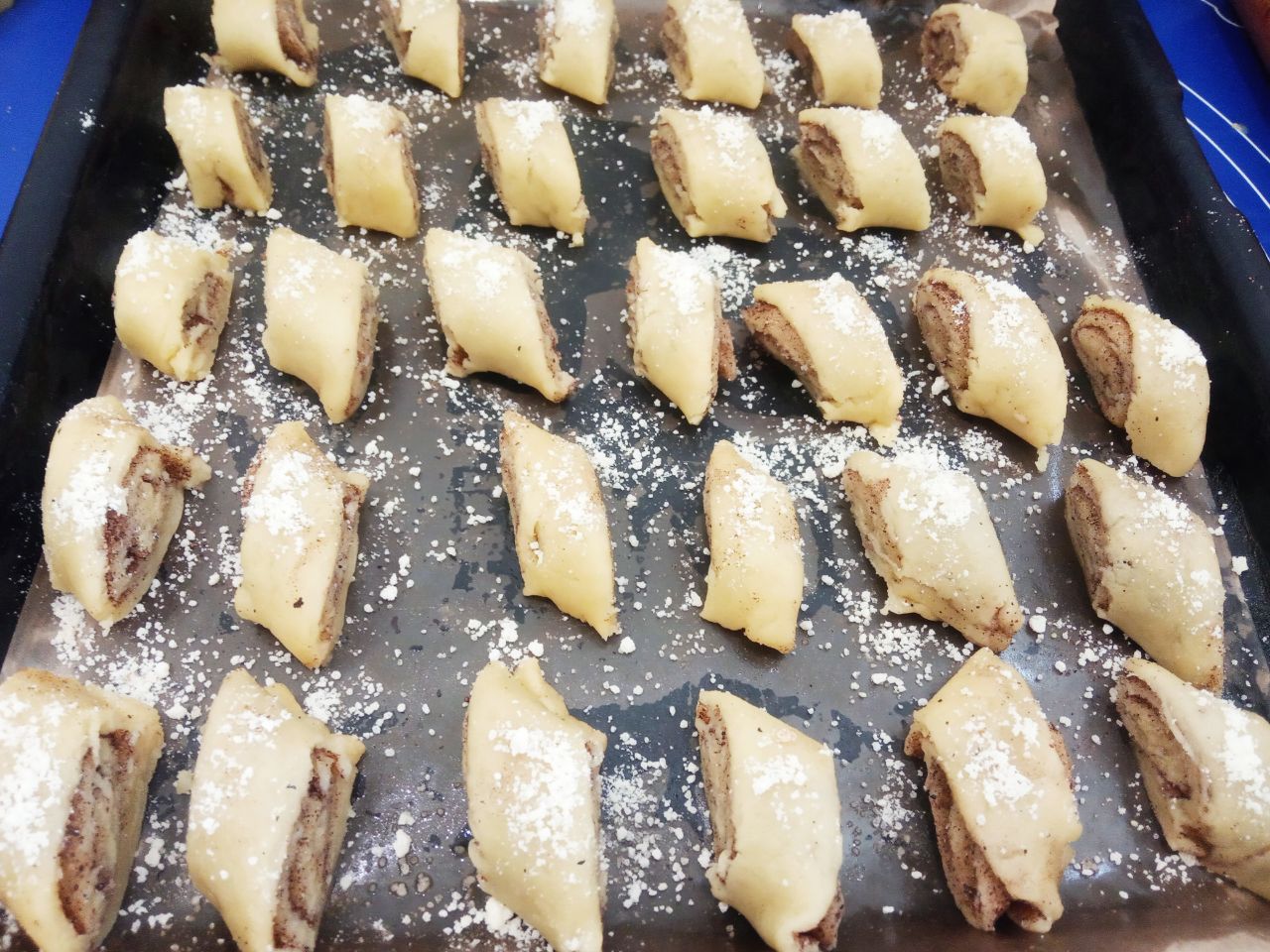 Печенье с корицей и мучной крошкой, песочное и рассыпчатое: Противень застилаем пергаментом и укладываем печенье с корицей. Сверху печенье посыпаем мучной крошкой.