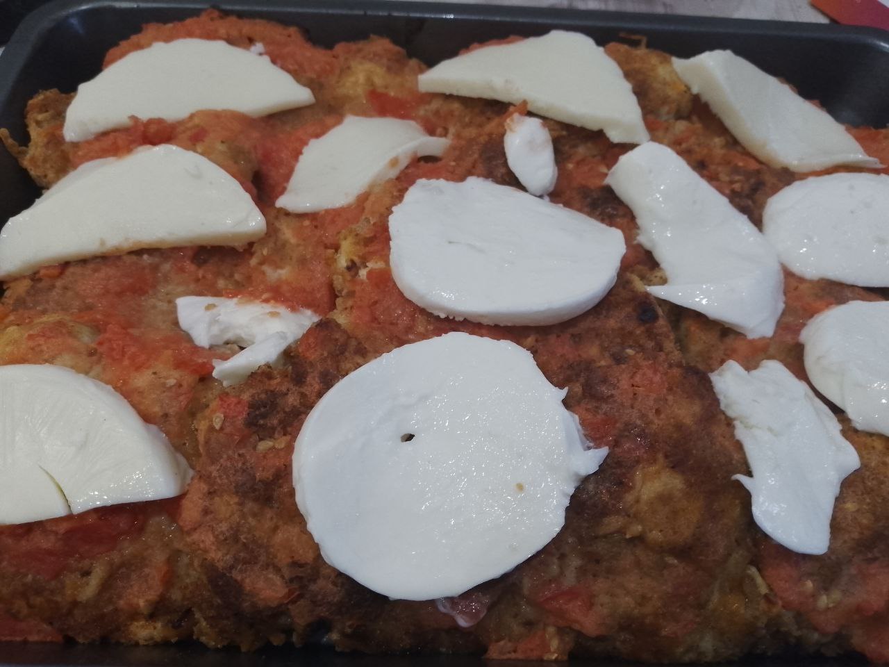 Курица пармиджано с протертыми помидорами и сыром: Достаем мясо из духовки, выкладываем сыр и возвращаем обратно в духовку на 5-7 минут, чтобы расплавился сыр.