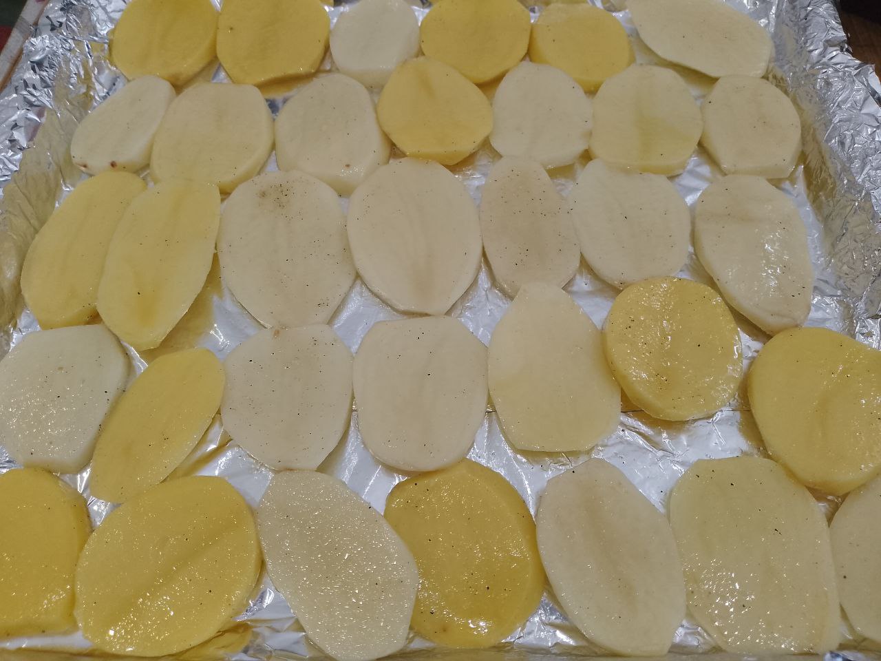 Картофель с мясом, помидорами и сыром запеченный в духовке: Противень застилаем фольгой или пергаментом и выкладываем кружочки картофеля.