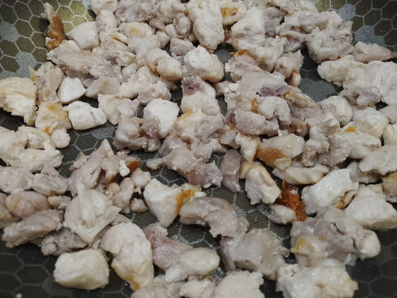 Макаронная запеканка с курицей, сыром и помидорами: Разогреваем сковороду с растительным маслом, кладем мясо, солим и посыпаем перцем и чесноком, обжариваем.