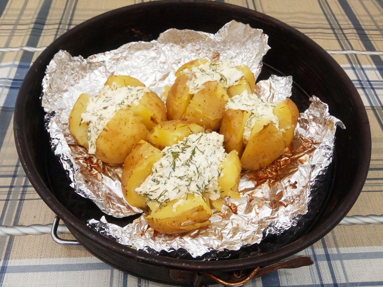Запеченный картофель с творогом и зеленью: Вынимаем картофель из духовки поливаем картофель сметаной, посыпаем зеленью по своему вкусу и подаем горячим.