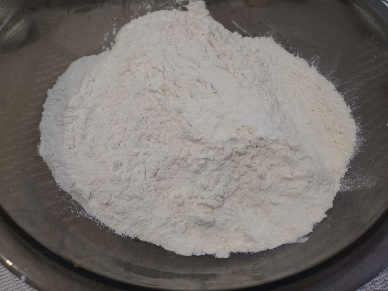 Пирог из песочной крошки, с творожной начинкой и замороженными ягодами: Муку просеиваем через сито, высыпаем сахар и разрыхлитель для теста, перемешиваем.