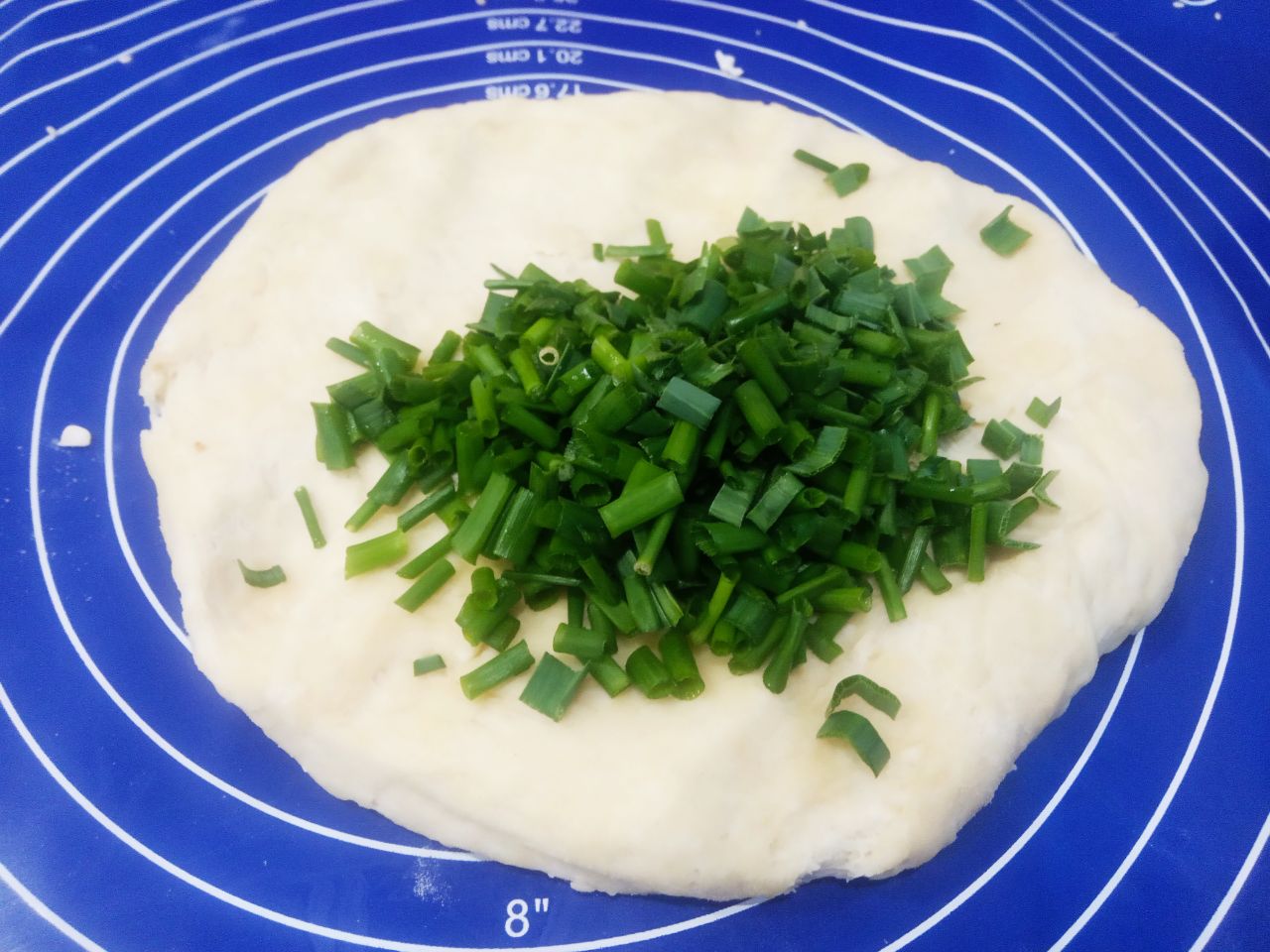 Солёное печенье с кунжутом и зеленым луком: Добавляем в одну половину теста зеленый лук с чесноком, перемешиваем, пока равномерно не распределится зелень.
