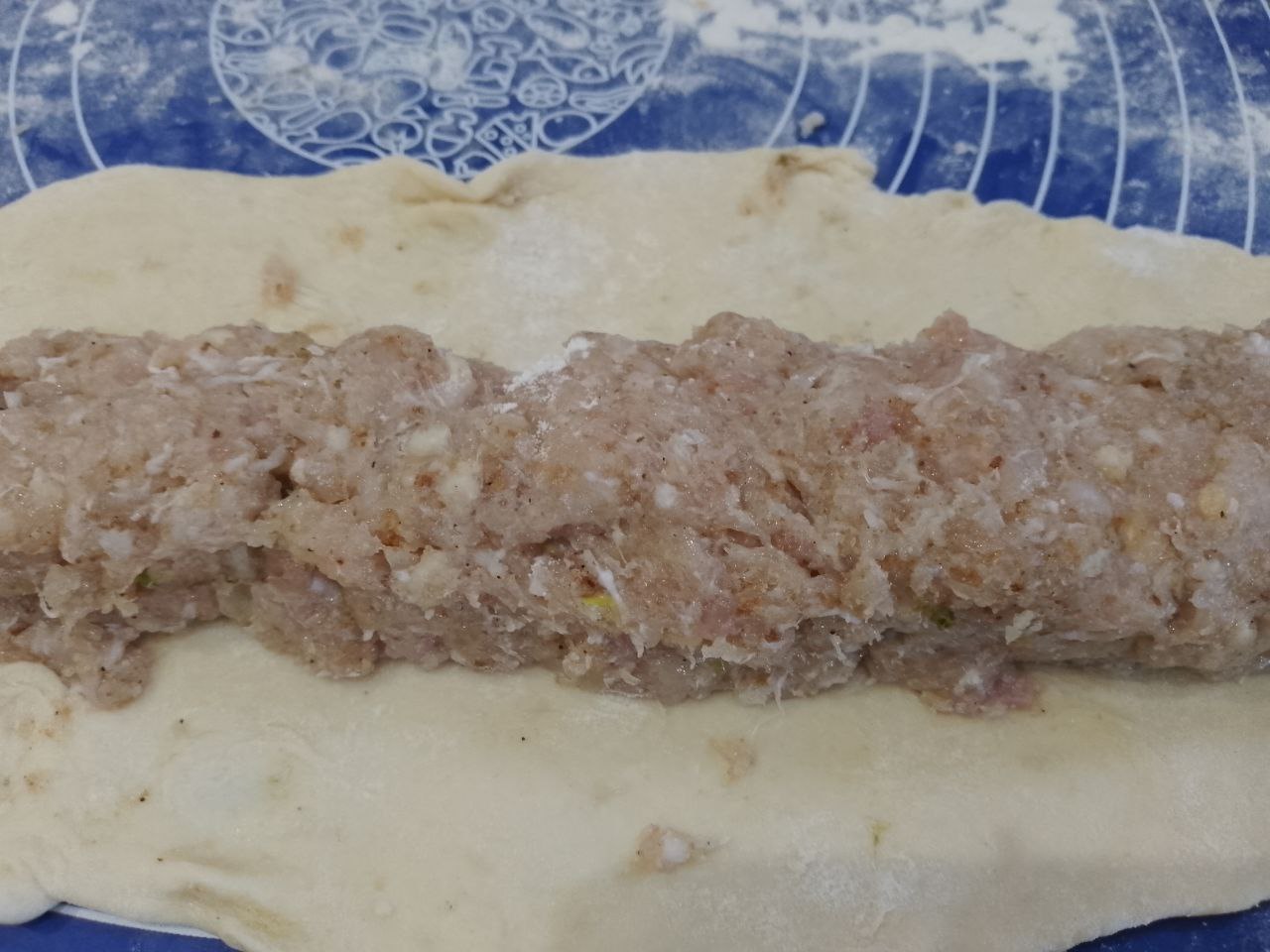 Вкусная мясная закуска в тесте и кляре, на сковороде: По длине теста выкладываем равномерно фарш и сворачиваем рулетом.