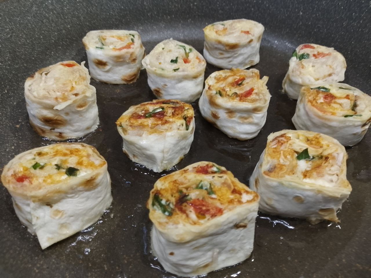 Вкусная закуска из лаваша, куриного филе и сыра, на сковороде: Обжариваем рулеты на небольшом огне до золотистой корочки с двух сторон.