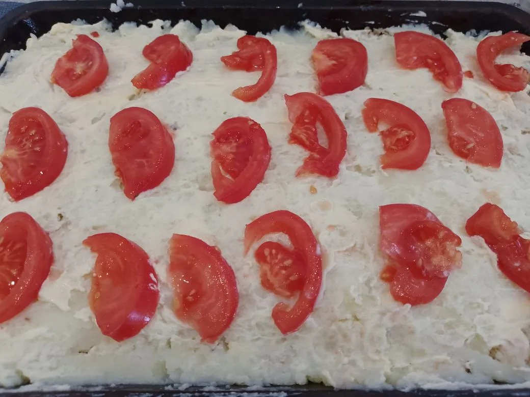 Картофельная запеканка с сыром, помидорами и куриным мясом: Выкладываем равномерно ломтики помидоров, смазываем сметаной и посыпаем измельченным зеленым луком.