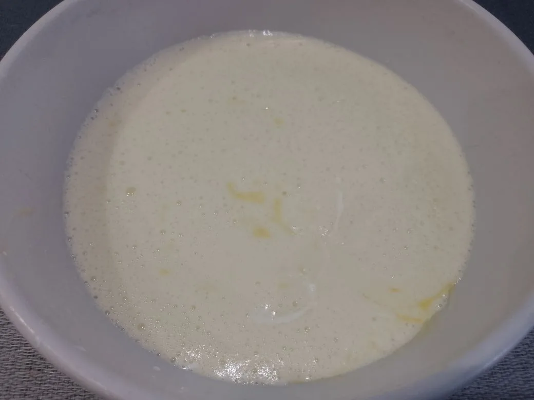 Шоколадный пирог на сметане, с клубникой и орехами: Добавляем в яичную смесь сметану и растопленное сливочное масло, перемешиваем.